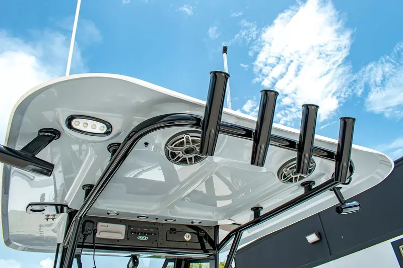 Slide: The Image of The image shows the T-top of a Sea Hunt Gamefish 25 boat with speakers and rod holders. - 15