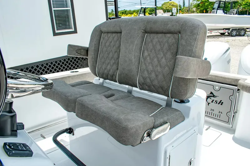 Slide: The Image of The image shows a gray, cushioned double seat on a boat, surrounded by white interior. - 18