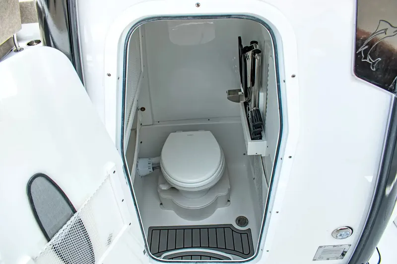 Slide: The Image of Interior view of a boat toilet with a white seat and gray flooring. - 19
