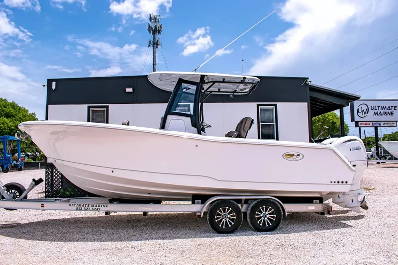 Slide: The Image of 2027 Sea Hunt Gamefish 25 on a trailer in front of a building. - 2