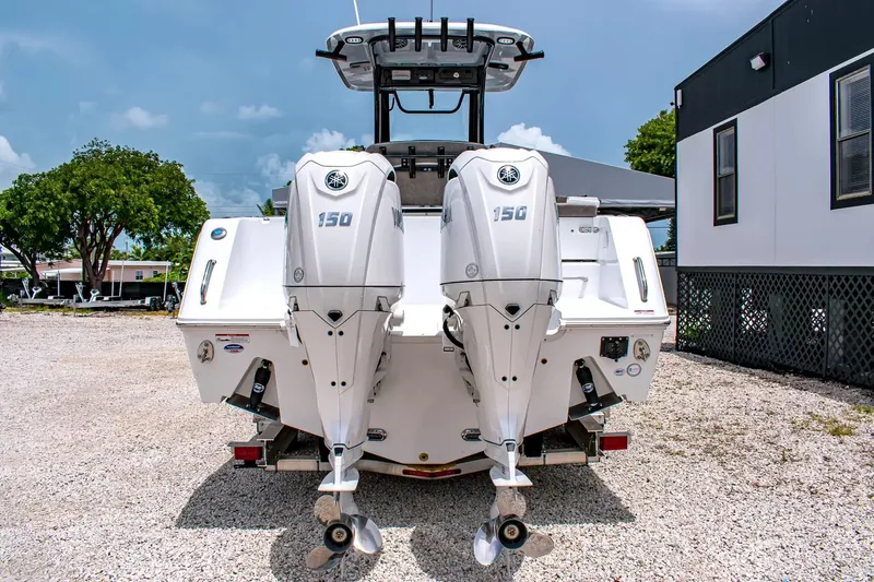 Slide: The Image of Two outboard motors on a Sea Hunt Gamefish 25 boat on a gravel lot. - 3
