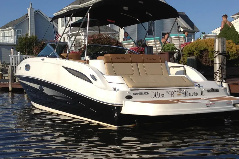 The Image of 2014 Sea Ray 260 Sundeck boat docked near waterfront homes. - 0