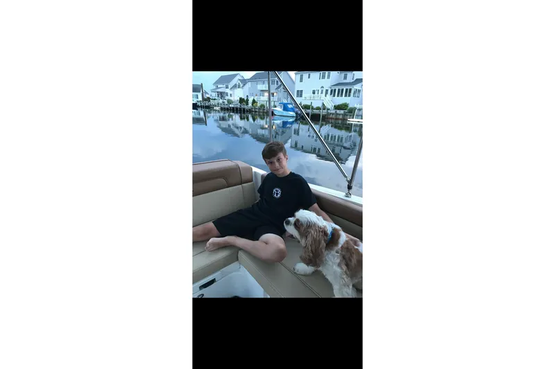 Slide: The Image of Young person and dog relaxing on a 2014 Sea Ray 260 Sundeck boat. - 16