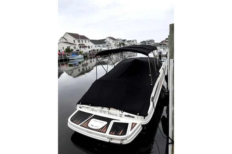 Slide: The Image of 2014 Sea Ray 260 Sundeck boat docked with black cover in a residential marina. - 2
