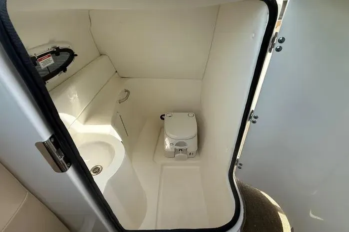 Slide: The Image of 2014 Sea Ray 260 Sundeck boat interior with compact bathroom and toilet. - 6