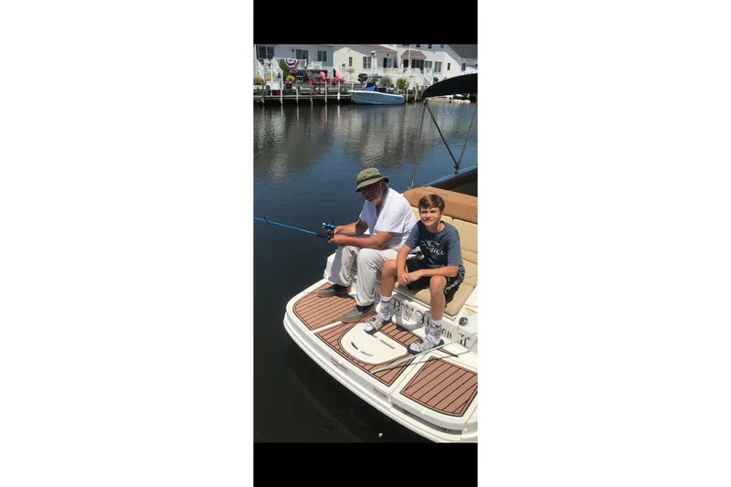 Slide: The Image of Two people fishing on a 2014 Sea Ray 260 Sundeck boat. - 8