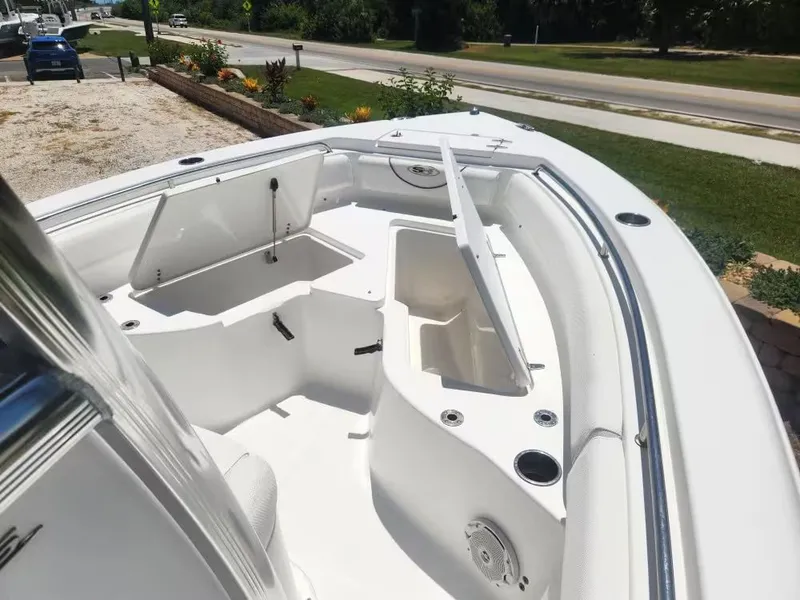 Slide: The Image of The image shows the bow area of a 2017 Sea Hunt Ultra 255 SE boat with open storage compartments. - 11