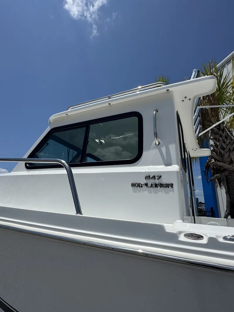 Slide: The Image of Side view of a Parker 247 Explorer boat with white hull and windows, under a blue sky. - 3