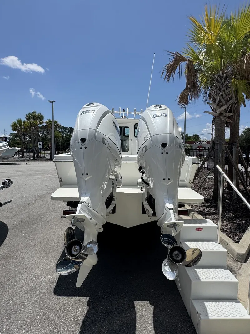 Slide: The Image of Two powerful outboard engines on a Parker 247 Explorer boat, parked on a sunny lot. - 5