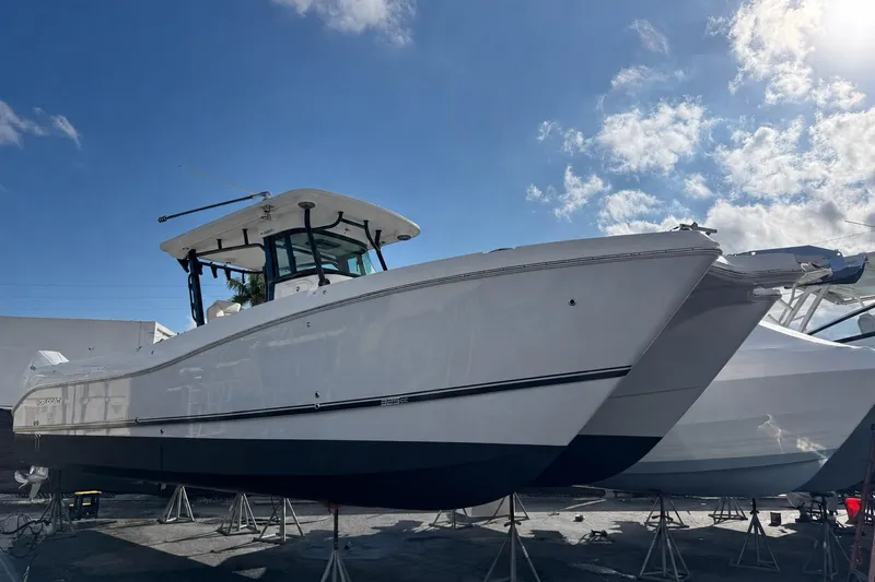 Slide: The Image of 2024 World Cat 325 CC boat on stands under a clear blue sky. - 1