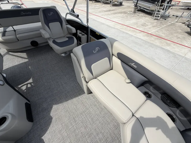 Slide: The Image of The image shows the interior of a Barletta A20UC pontoon boat with beige and gray seating. - 11