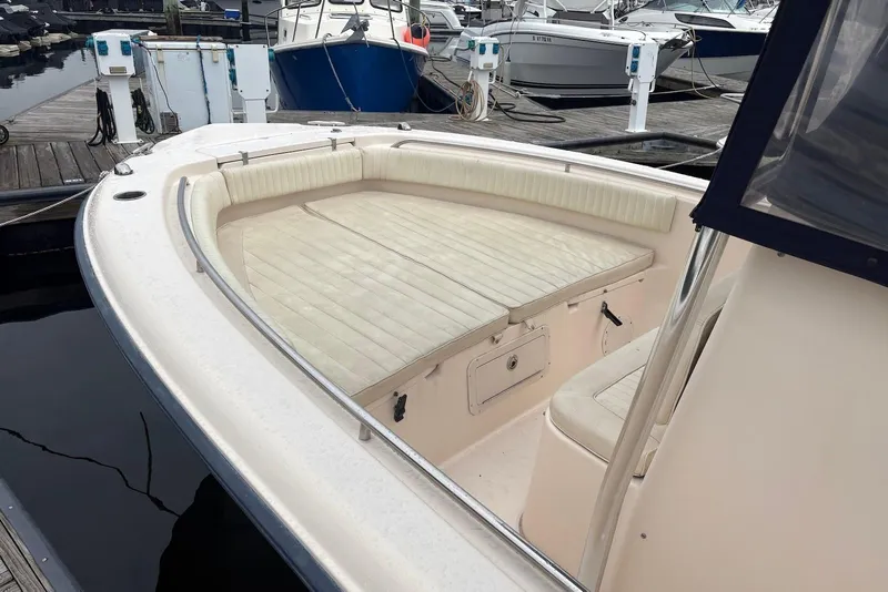 Slide: The Image of 2006 Grady-White Advance 257 boat interior at marina, featuring cushioned seating and storage. - 8