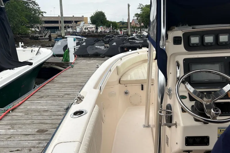 Slide: The Image of 2006 Grady-White Advance 257 boat docked, featuring steering console and marina background. - 7