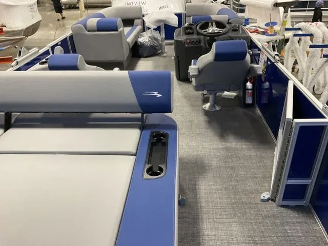 Slide: The Image of The image shows the interior of a 2025 Bennington S Swingback 22 SSB with blue and gray seating. - 12