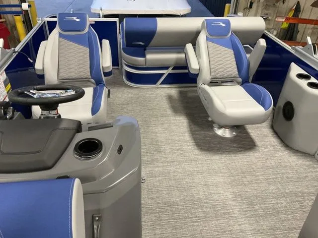 Slide: The Image of The image shows the interior of a 2025 Bennington S Swingback 22 SSB. It features blue and gray seating with a modern helm. - 9