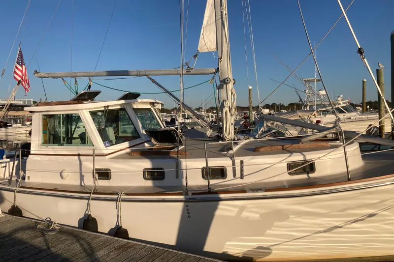 The Image of A 1989 Cape Dory 30 Motorsailer docked in a marina. It features a sturdy design and white cabin. - 0
