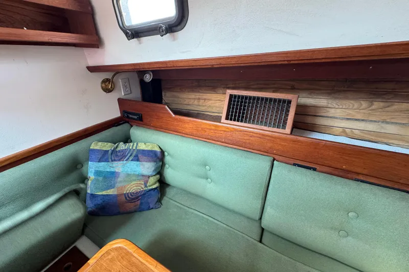Slide: The Image of Interior of 1989 Cape Dory 30 Motorsailer with green cushions and colorful pillow. - 28