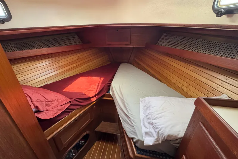 Slide: The Image of Cozy cabin interior of 1989 Cape Dory 30 Motorsailer with wooden paneling and twin beds. - 30