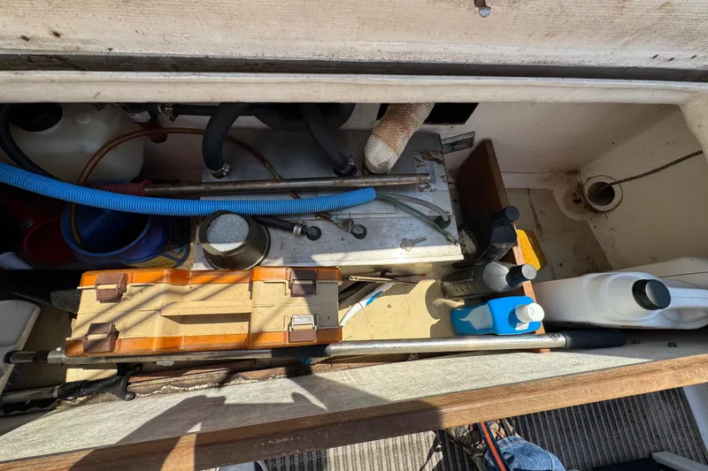 Slide: The Image of A view into the engine compartment of a 1989 Cape Dory 30 Motorsailer with various tools and equipment. - 44