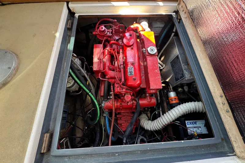 Slide: The Image of Engine compartment of a 1989 Cape Dory 30 Motorsailer, featuring a red engine and wiring. - 20