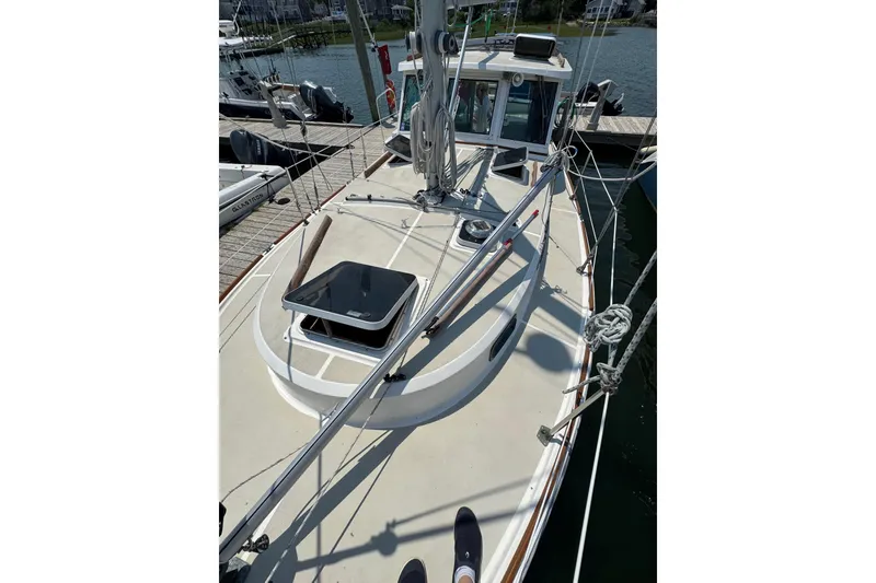 Slide: The Image of 1989 Cape Dory 30 Motorsailer deck view at marina, showcasing rigging and hatch. - 9