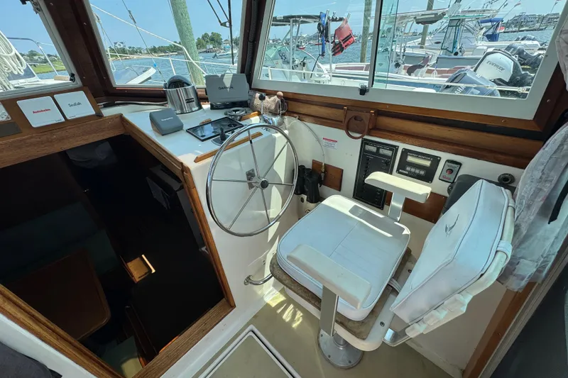 Slide: The Image of Interior helm of 1989 Cape Dory 30 Motorsailer with steering wheel and navigation equipment. - 11