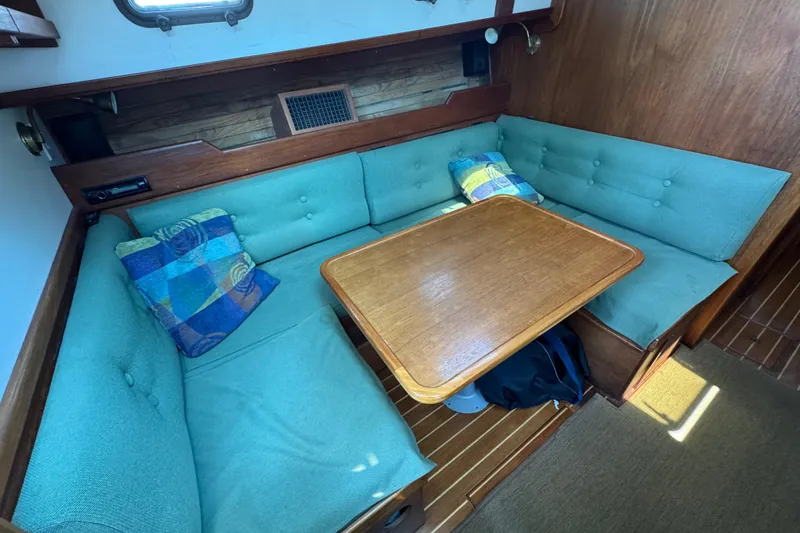 Slide: The Image of Cozy interior of 1989 Cape Dory 30 Motorsailer with teal seating and wooden table. - 27
