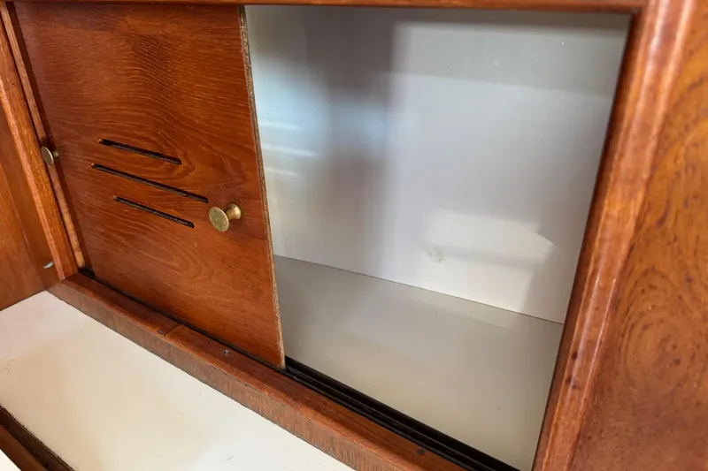 Slide: The Image of Wooden cabinet interior on a 1989 Cape Dory 30 Motorsailer, featuring sliding doors. - 32