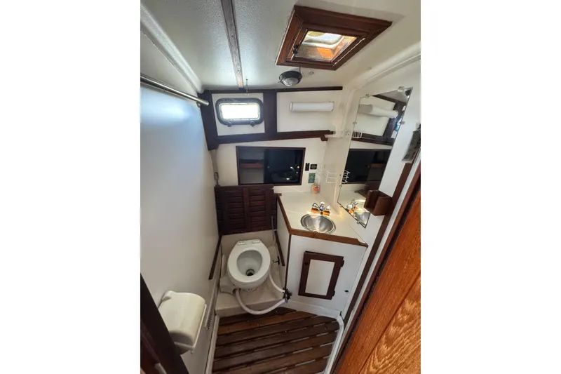 Slide: The Image of 1989 Cape Dory 30 Motorsailer bathroom with wooden accents and compact design. - 29