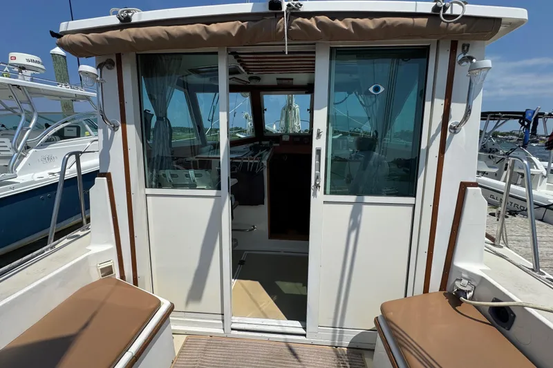 Slide: The Image of 1989 Cape Dory 30 Motorsailer cockpit with sliding doors and seating, docked at marina. - 42