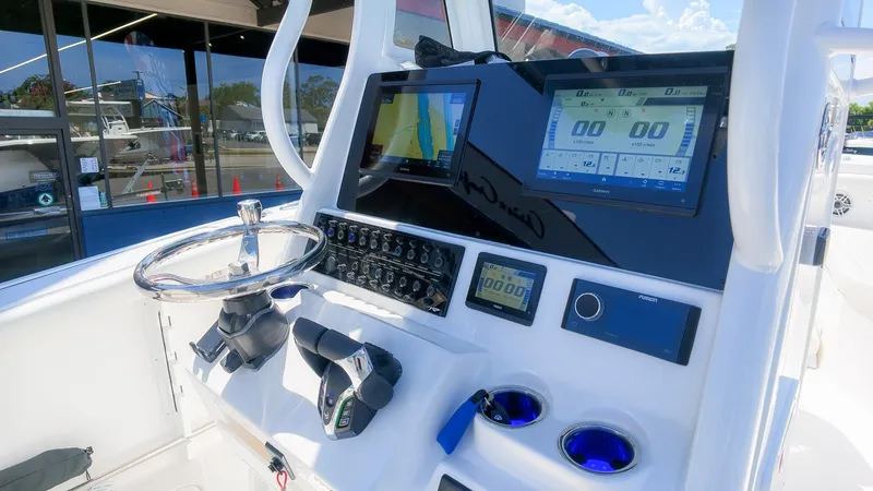 Slide: The Image of The image shows the helm of a Tidewater 272 CC Adventure boat with modern instruments and screens. - 24