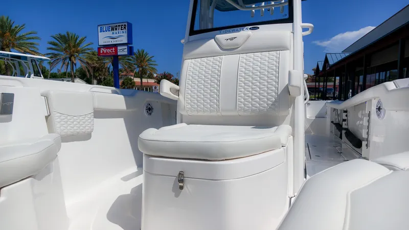 Slide: The Image of The image shows the cockpit of a 2027 Tidewater 272 CC Adventure boat with white upholstery. - 34