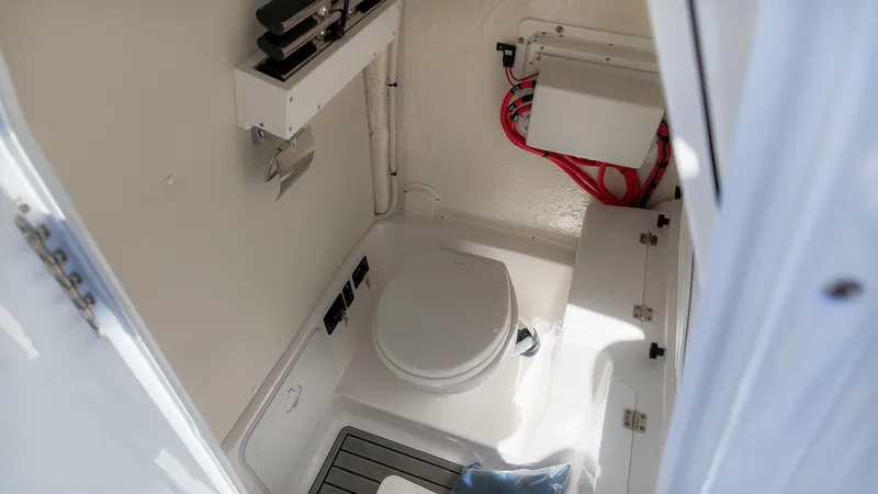 Slide: The Image of Interior view of a boat toilet with a white toilet and storage space. - 36