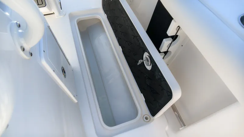 Slide: The Image of An open storage compartment on a boat with a black lid and a lock. - 10