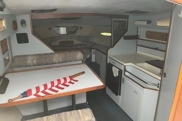 The Image of Interior of 1989 Sea Ray 300 Sundancer boat with dining area and kitchenette. - 0
