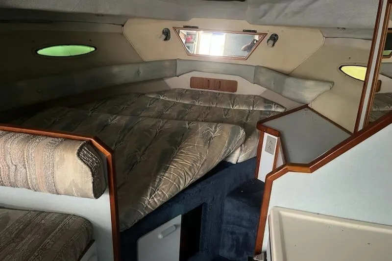 Slide: The Image of 1989 Sea Ray 300 Sundancer cabin interior with cozy sleeping area and nautical decor. - 1