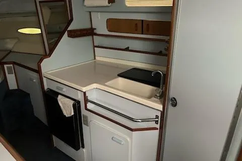 Slide: The Image of 1989 Sea Ray 300 Sundancer interior kitchen with sink, cabinets, and countertop. - 14