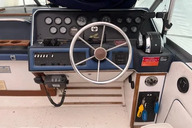 Slide: The Image of 1989 Sea Ray 300 Sundancer helm with steering wheel, gauges, and control panel. - 2
