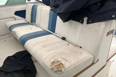 Slide: The Image of Worn seating on 1989 Sea Ray 300 Sundancer boat with visible damage and blue accents. - 8