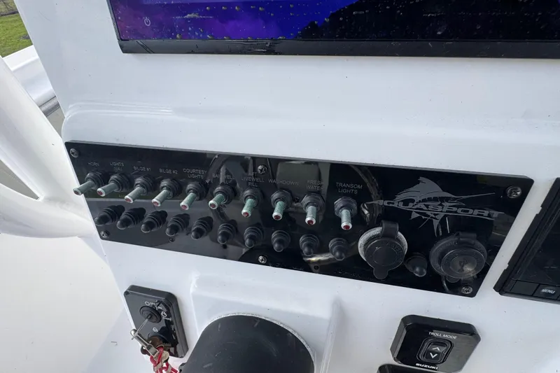 Slide: The Image of Control panel of 2022 Aquasport 2500 Center Console boat with switches and dials. - 33