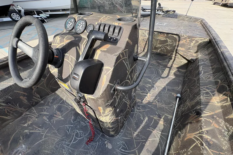 Slide: The Image of 2018 Excel 1854 Shallow Water F4 Console boat interior with camouflage design and steering controls. - 12
