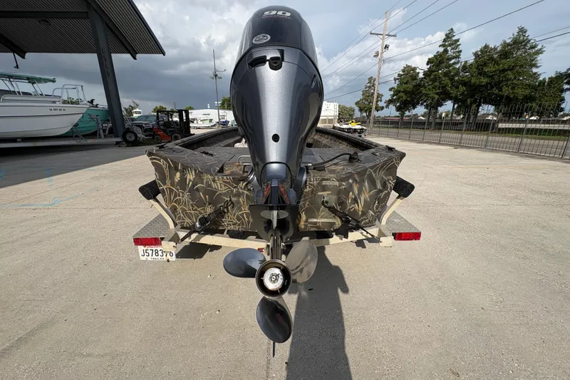 Slide: The Image of 2018 Excel 1854 Shallow Water F4 Console boat with outboard motor, parked outdoors. - 4