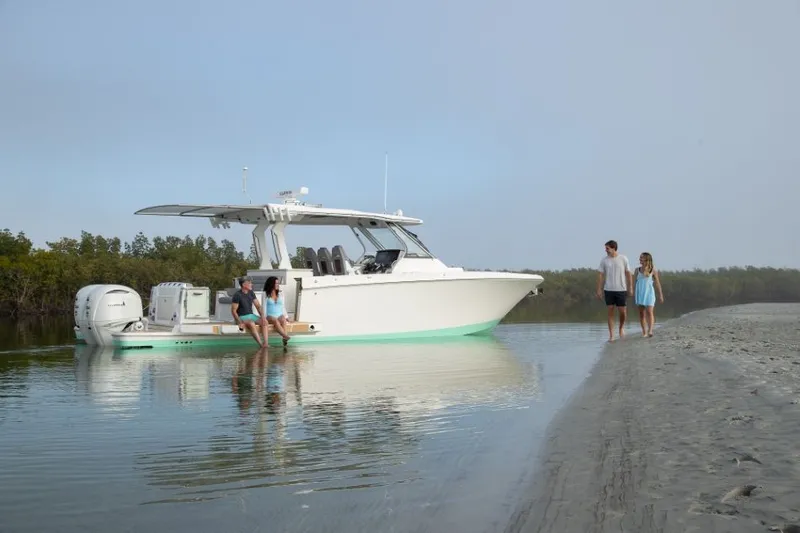 Slide: The Image of Regal 34 SAV 2027: Luxurious boat at a calm shore with people on board and walking on the beach. - 13