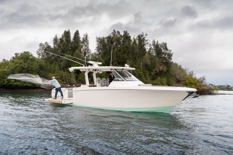 Slide: The Image of An angler casts a net from a Regal 34 SAV boat on calm water. - 16