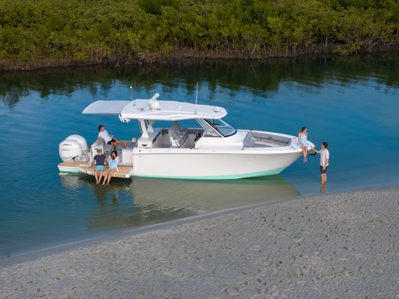 Slide: The Image of A modern yacht with people on board, anchored in a calm, shallow bay. - 19