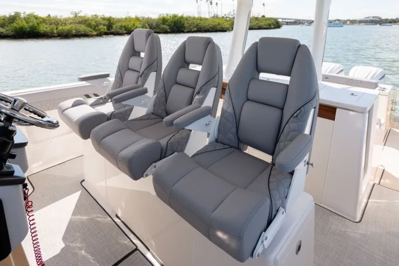 Slide: The Image of Three luxurious, padded seats on a boat overlooking the water. - 40