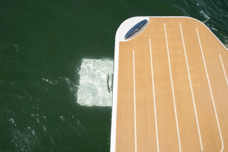 Slide: The Image of A wooden boat platform with a metal handle, hovering above the water. - 43