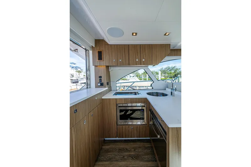 Slide: The Image of Modern kitchen interior of 2025 Cruisers Yachts 50 Cantius, featuring sleek wood cabinetry and appliances. - 13
