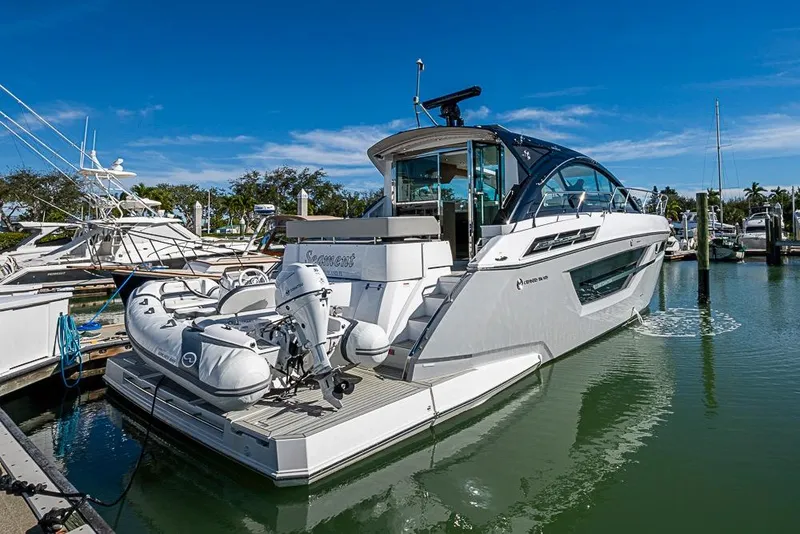 Slide: The Image of 2025 Cruisers Yachts 50 Cantius docked in a marina under clear blue skies. - 2