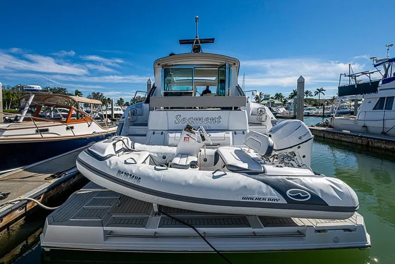 Slide: The Image of 2025 Cruisers Yachts 50 Cantius docked with inflatable boat, sunny marina backdrop. - 3